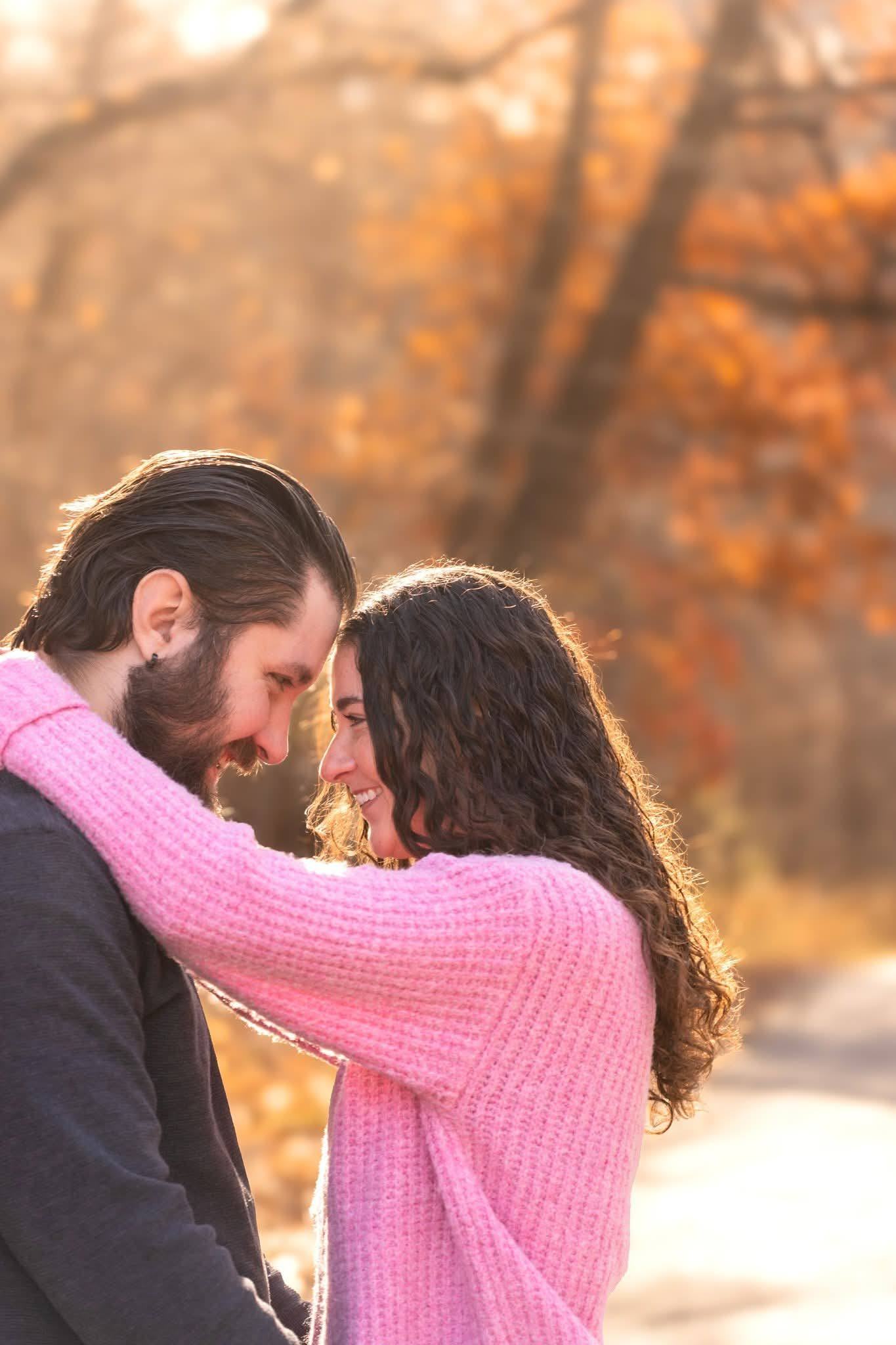 A couple resting their foreheads together on a woodland path