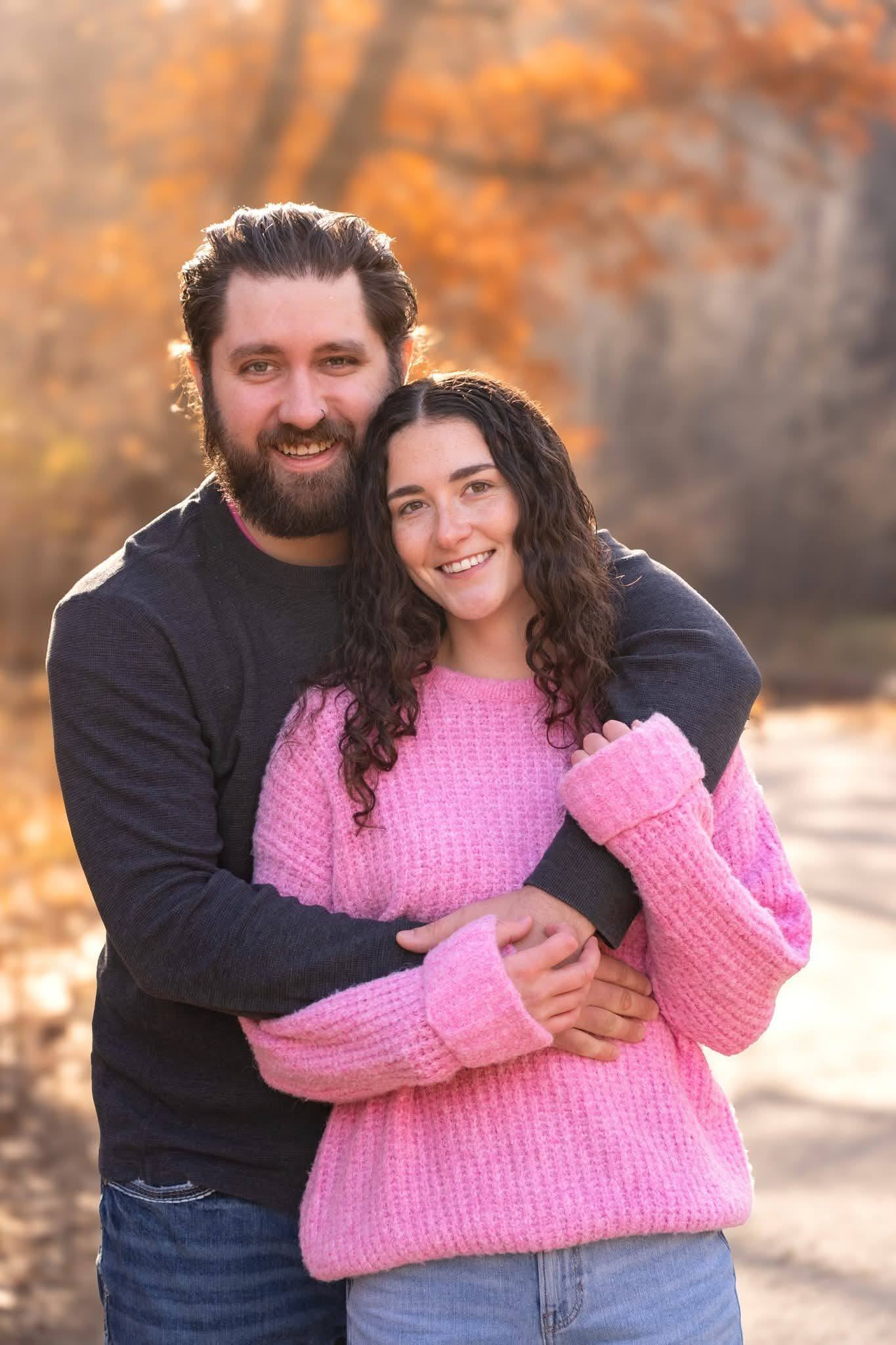 A couple standing together among autumn trees