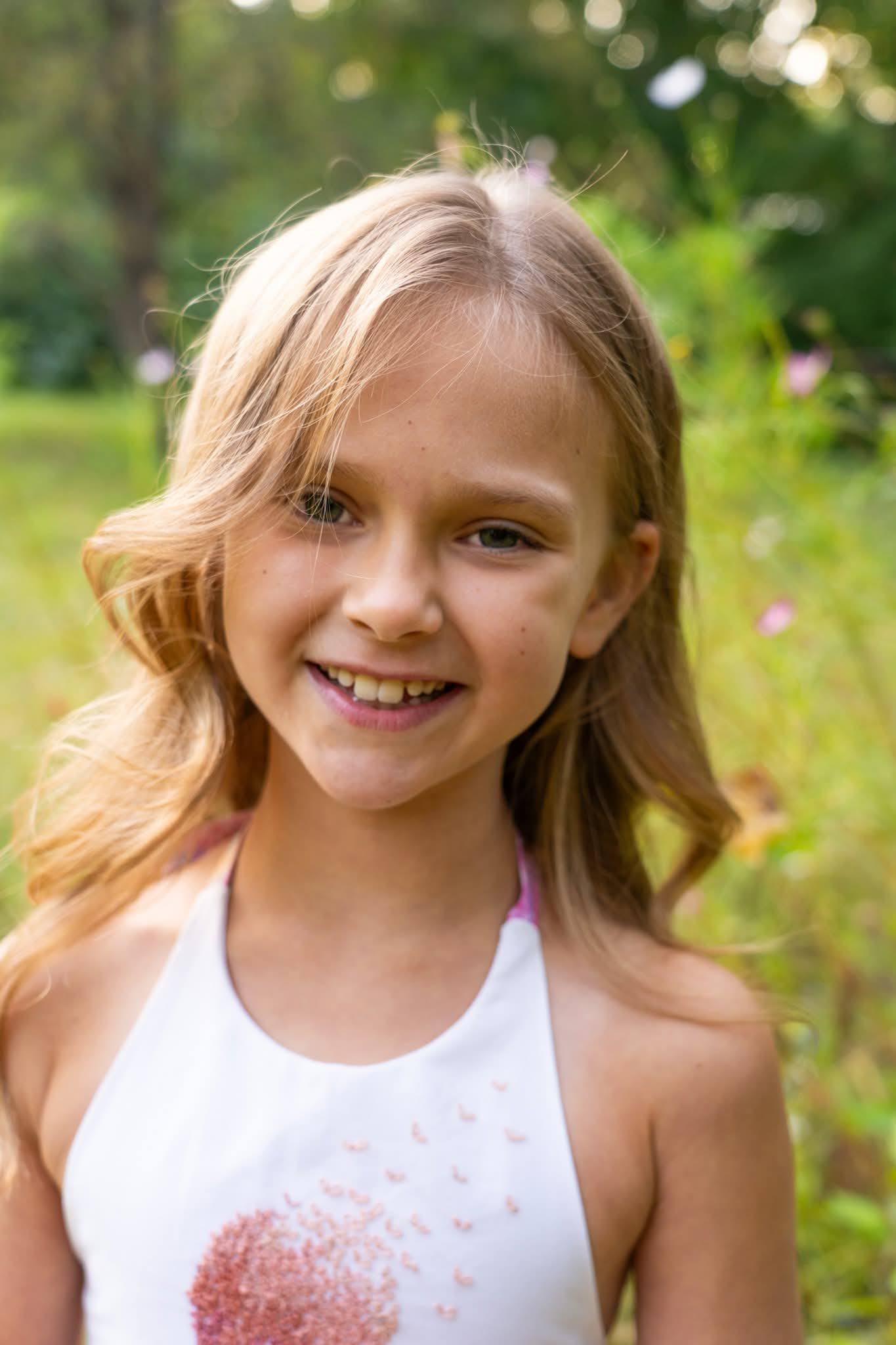 A smiling girl outdoors in soft afternoon light